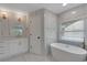 Bright bathroom features a soaking tub, marble-look tile, and modern fixtures at 1095 Lyndhurst Way, Roswell, GA 30075
