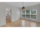 Sunlit dining room featuring hardwood floors, wainscoting, and views of the landscaped backyard at 1095 Lyndhurst Way, Roswell, GA 30075