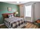 Comfortable bedroom with natural light, a wooden bed frame, and olive green walls at 6298 Pierless Ave, Sugar Hill, GA 30518