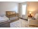 Charming Bedroom with neutral tones, a wooden crib, and a comfortable chair at 6298 Pierless Ave, Sugar Hill, GA 30518