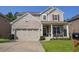 Charming two-story home featuring a brick facade, inviting front porch and well-manicured landscaping at 6298 Pierless Ave, Sugar Hill, GA 30518