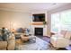 Inviting living room with a corner fireplace, large windows, and comfortable seating at 6298 Pierless Ave, Sugar Hill, GA 30518