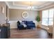 Comfortable living room with wainscoting, a blue sofa, decorative pillows, and a large window at 6298 Pierless Ave, Sugar Hill, GA 30518