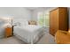 Cozy bedroom with soft carpeting, a comfortable bed, and a window that provides natural light and backyard views at 2015 Samuel Close Ct, Alpharetta, GA 30009