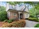 Brick clubhouse exterior with manicured landscaping, including flowers, shrubs, and a paved walkway at 2015 Samuel Close Ct, Alpharetta, GA 30009