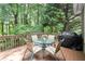Inviting outdoor deck with a glass table and chairs, perfect for enjoying peaceful views of the surrounding greenery at 2015 Samuel Close Ct, Alpharetta, GA 30009