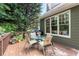 Relaxing deck area featuring a glass table, four chairs, and a gas grill for outdoor cooking and entertaining at 2015 Samuel Close Ct, Alpharetta, GA 30009