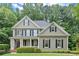 Classic two-story home with a welcoming front porch, complemented by lush landscaping and a well-maintained lawn at 2015 Samuel Close Ct, Alpharetta, GA 30009