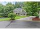 Elegant two-story home featuring a manicured lawn, mature trees, and a circular driveway for enhanced curb appeal at 2015 Samuel Close Ct, Alpharetta, GA 30009