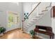 Sunlit foyer featuring hardwood floors and elegant staircase with white railing at 2015 Samuel Close Ct, Alpharetta, GA 30009