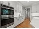 Well-equipped kitchen showcasing stainless steel appliances, white cabinets, and stone countertops at 2015 Samuel Close Ct, Alpharetta, GA 30009