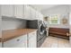 Functional laundry room with ample counter space, storage cabinets, and modern washer and dryer at 2015 Samuel Close Ct, Alpharetta, GA 30009
