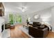 Inviting living room features hardwood floors, a cozy fireplace, and large windows showcasing the lush greenery outside at 2015 Samuel Close Ct, Alpharetta, GA 30009