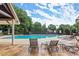 Outdoor pool with lounge chairs and umbrellas on the deck area, with a view of the surrounding trees and sky at 2015 Samuel Close Ct, Alpharetta, GA 30009