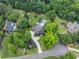 Overhead shot of a gorgeous home nestled among trees, featuring manicured landscaping and a circular driveway at 407 Maple Ridge Ct, Cumming, GA 30028