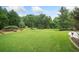 Expansive backyard featuring lush green grass and mature trees offering privacy and a serene outdoor space at 407 Maple Ridge Ct, Cumming, GA 30028