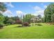 Expansive backyard featuring lush landscaping and a view of the home at 407 Maple Ridge Ct, Cumming, GA 30028