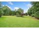 Expansive backyard featuring lush green lawn, mature trees, and well-manicured landscaping at 407 Maple Ridge Ct, Cumming, GA 30028
