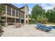 Spacious backyard patio with outdoor dining, lounge chairs, and views of lush landscaping and the home's exterior at 407 Maple Ridge Ct, Cumming, GA 30028