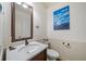 Elegant half bathroom with marble sink, decorative mirror, wainscotting, and boat-themed wall decor at 407 Maple Ridge Ct, Cumming, GA 30028