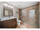 Bathroom with wood vanity, walk-in shower, and stone floor at 407 Maple Ridge Ct, Cumming, GA 30028