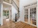 Spacious foyer with hardwood floors, a staircase with iron railings, and glass-paneled doors at 407 Maple Ridge Ct, Cumming, GA 30028