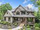 Beautiful home with stone and shake siding, covered porch, and manicured landscaping at 407 Maple Ridge Ct, Cumming, GA 30028