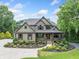 Inviting home featuring a grand driveway, beautiful landscaping, and a covered front porch at 407 Maple Ridge Ct, Cumming, GA 30028