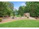 Charming backyard garden featuring raised beds, a potting shed, and lush landscaping at 407 Maple Ridge Ct, Cumming, GA 30028