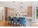 Gourmet kitchen with custom cabinets, granite countertops, and bar stool seating at 407 Maple Ridge Ct, Cumming, GA 30028