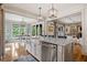 Modern kitchen featuring a large island, stainless steel appliances, and a sink with a large window at 407 Maple Ridge Ct, Cumming, GA 30028