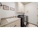 Functional laundry room with modern washer and dryer, ample storage, and a utility sink at 407 Maple Ridge Ct, Cumming, GA 30028