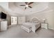 Relaxing main bedroom with tray ceiling, soft lighting, plush carpet, and ensuite bathroom access at 407 Maple Ridge Ct, Cumming, GA 30028
