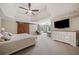 Relaxing main bedroom features a tray ceiling, a ceiling fan, and access to en-suite bathroom at 407 Maple Ridge Ct, Cumming, GA 30028