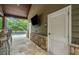 The covered outdoor kitchen includes a bathroom and is adjacent to the pool and outdoor bar at 407 Maple Ridge Ct, Cumming, GA 30028