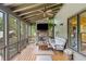 A relaxing covered patio with a stone fireplace, TV, comfortable seating, and views of the landscaped backyard at 407 Maple Ridge Ct, Cumming, GA 30028