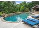 A luxurious backyard oasis with a custom pool, stone accents, waterfall features, and a covered outdoor kitchen at 407 Maple Ridge Ct, Cumming, GA 30028