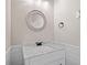 Clean and crisp white powder room featuring a white vanity with a marble top and a round mirror at 407 Maple Ridge Ct, Cumming, GA 30028