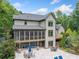 Home's back exterior featuring a screened porch and a large patio at 407 Maple Ridge Ct, Cumming, GA 30028