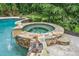 An attached in-ground spa is surrounded by natural stone with an integrated waterfall feature at 407 Maple Ridge Ct, Cumming, GA 30028