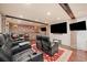 Home theater featuring comfortable seating, large screen, and brick wall accents at 407 Maple Ridge Ct, Cumming, GA 30028