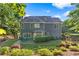 Exterior view of home's backyard, featuring a patio and beautifully landscaped yard at 1945 Barrett Dr, Cumming, GA 30040