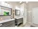Bathroom with dual vanities, modern fixtures, decorative mirrors, and a view of the lush greenery outside at 1945 Barrett Dr, Cumming, GA 30040
