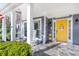 Inviting front porch featuring white columns, a cheerful yellow door, and slate flooring at 1945 Barrett Dr, Cumming, GA 30040