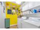 Bright laundry room with white washer and dryer, colorful decor, and ample storage space at 1945 Barrett Dr, Cumming, GA 30040