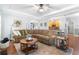Spacious living room with a comfortable brown sofa, hardwood floors, and tray ceiling at 1945 Barrett Dr, Cumming, GA 30040