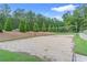Outdoor volleyball court with sand, net, and surrounding green space and trees at 1945 Barrett Dr, Cumming, GA 30040