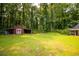Large backyard with green grass and mature trees at 20 Lisa Ct, Stockbridge, GA 30281