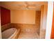 Well-lit bathroom features a jacuzzi tub, shower, and tiled floors with a ceiling fan at 20 Lisa Ct, Stockbridge, GA 30281