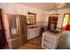Well lit kitchen features stainless steel fridge, white cabinets, gray countertops, and an island cooktop at 20 Lisa Ct, Stockbridge, GA 30281